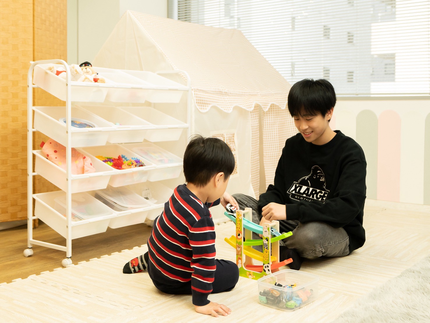 スタッフと子どもが一緒におもちゃで遊ぶようす